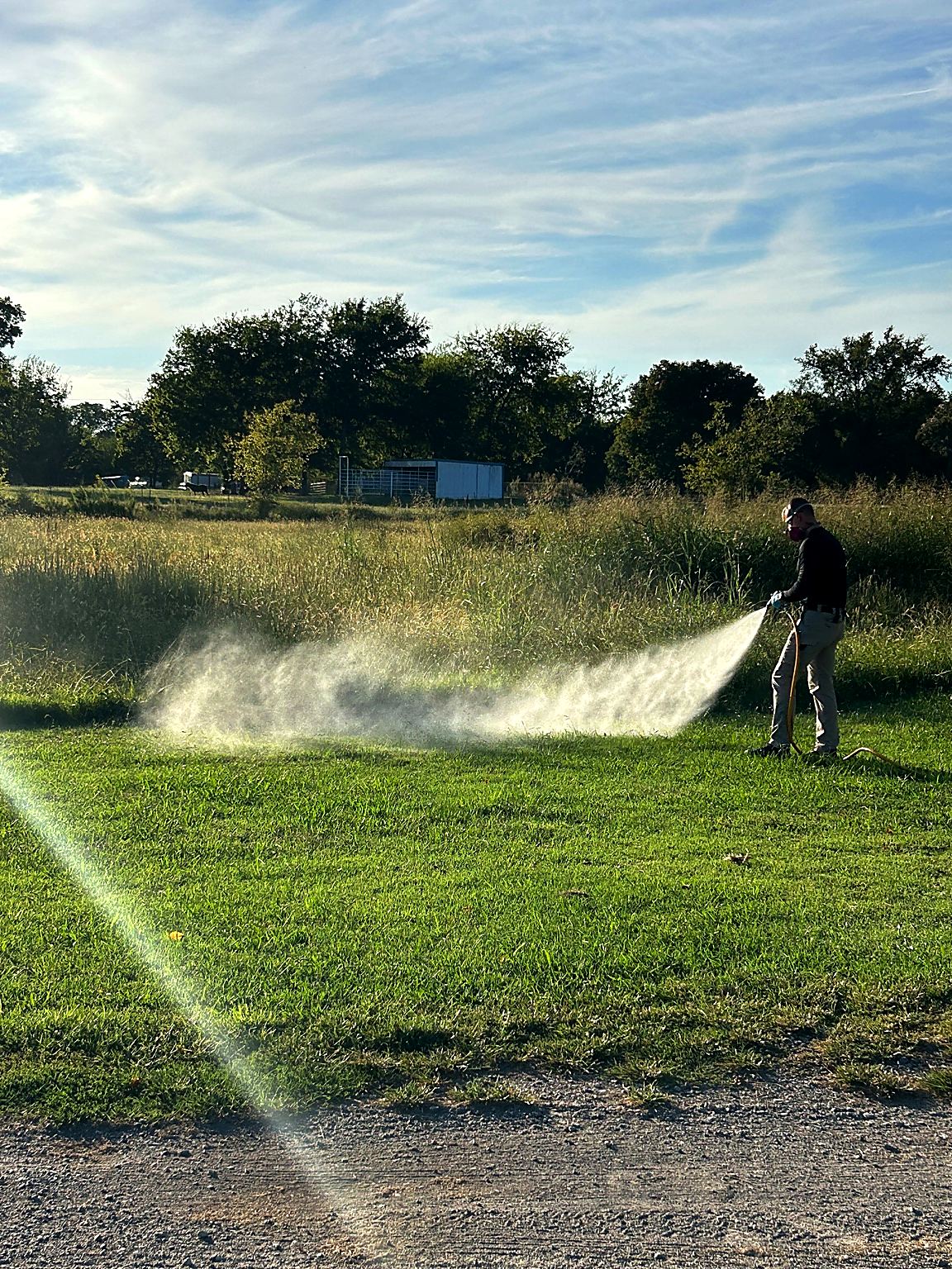 Bret spraying a yard for mosquitoes and outdoor pests