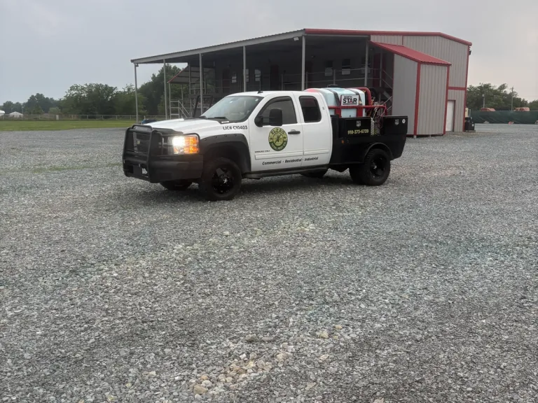 Elza’s Total Pest Control service truck outside a metal building