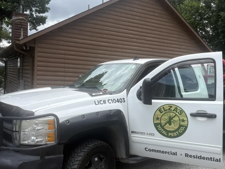 Elza’s Total Pest Control service truck at a residential property